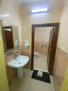 a bathroom with a sink and a shower and a toilet at العييري للشقق المخدومة المدينة 3 in Al Madinah