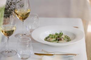 a table with a plate of food and glasses of wine at Hotel Aurora in Lech am Arlberg