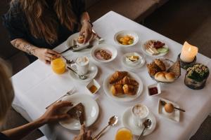 a table topped with plates of breakfast foods and orange juice at Hotel Aurora in Lech am Arlberg +83 photos