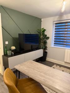 ein Wohnzimmer mit Tisch und Fernseher in der Unterkunft Lovely flat close to Tewkesbury town centre! in Tewkesbury