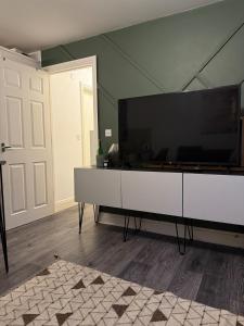 ein Wohnzimmer mit einem großen Flachbildfernseher in der Unterkunft Lovely flat close to Tewkesbury town centre! in Tewkesbury + 3 Fotos