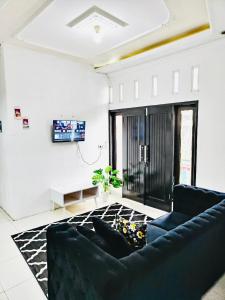 un salon avec un canapé et une télévision dans l'établissement Aurora villa Dieng, à Diyeng