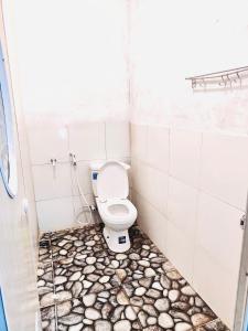 une salle de bain avec toilettes dans une pièce carrelée dans l'établissement Aurora villa Dieng, à Diyeng