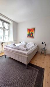 a bedroom with a white bed with a rug at ApartmentInCopenhagen Apartment 200 in Copenhagen