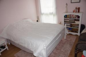 a white bed in a bedroom with a window at Comfort & quiet with garden in Saint-herblain in Saint-Herblain