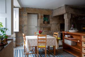 a dining room with a table and chairs at Casa dos Livros - Guest House in Vila Nova de Tazem