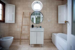 a bathroom with a sink and a mirror and a tub at Casa dos Livros - Guest House in Vila Nova de Tazem +158 photos