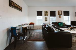 a living room with a couch and a table at Surf's Up - pet-friendly Fitzroy lifestyle home in New Plymouth