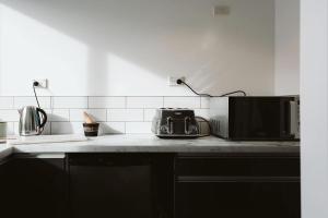 a kitchen counter with a toaster and a microwave at Surf's Up - pet-friendly Fitzroy lifestyle home in New Plymouth
