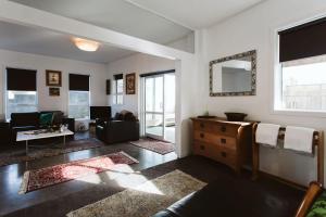 a living room with a couch and a dresser at Surf's Up - pet-friendly Fitzroy lifestyle home in New Plymouth