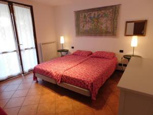 a bedroom with a bed with a red comforter at Rosmarino 1 in Agra