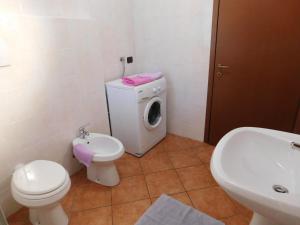 a bathroom with a toilet sink and a washing machine at Rosmarino 1 in Agra +26 photos