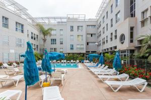 a pool with chairs and umbrellas in a hotel at 3BR Buddha Penthouse - Solarium & Pool in Sardina