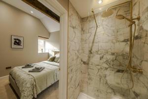 a master bathroom with a shower and a bed at The Old Loft House in Chew Stoke in Chew Stoke