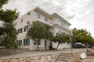 a large white building with a table in front of it at Apartments and Rooms Kod Mate in Tribanj-Krušćica