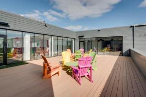 a group of colorful chairs and tables on a deck at The Spot - Luxurious 3-Bedroom Apartment in the Heart of Winnipeg in Tuxedo