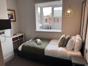 ein kleines Schlafzimmer mit einem Bett und einem Fenster in der Unterkunft Regency Guest House in Cambridge