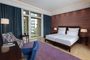Habitación de hotel con cama, silla y sofá en Le Gray, en Beirut