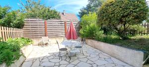 een terras met een tafel, stoelen en een parasol bij LA Grâce d'Amboise in Amboise