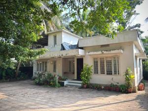 a white house with a driveway in front of it at Lenzo Home Stays in Kāsaragod