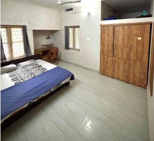 a bedroom with a bed and a desk in it at Lenzo Home Stays in Kāsaragod