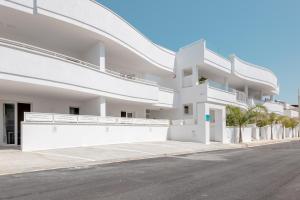 a white building with a street in front of it at Diva Luxury Suite in Torre San Giovanni Ugento