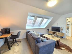 a living room with a couch and a table and a tv at Appartement Turmblick in Marienhafe