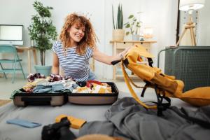 a woman is putting clothes in a suitcase at Appartement Turmblick in Marienhafe