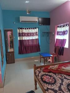 a bedroom with blue and purple walls and a bed at Sarat guest house in Digha
