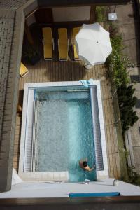 a person in a swimming pool with an umbrella at Adler Adelboden in Adelboden