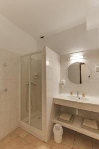 een badkamer met douche en wastafel bij Hotel des Etrangers in Bonifacio