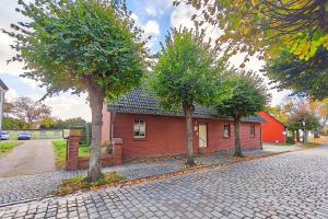 a red brick house with two trees in front of it at Ferienwohnung Merkel in Koserow