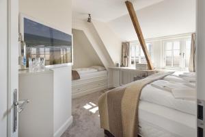 een witte slaapkamer met een bed en twee ramen bij Seaside in Klappholttal