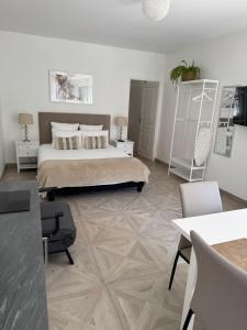a bedroom with a bed and a table and chairs at Manoir et Appartements avec piscine au Domaine de Bize Mirepoix in Mirepoix