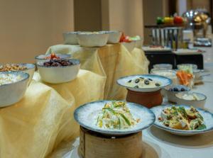 a table with many bowls of food on it at EL DE Olive Aero Suites Near Delhi International Airport in New Delhi +23 photos