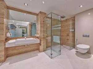a bathroom with a toilet and a sink and a shower at EL DE Olive Aero Suites Near Delhi International Airport in New Delhi