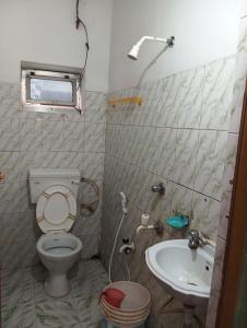a bathroom with a toilet and a sink at Sarat guest house in Digha +9 photos