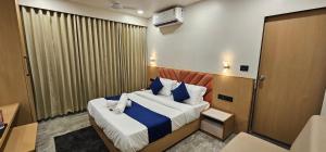 a bedroom with a bed with blue and white pillows at Hotel Earth Orbit in Gandhinagar +7 photos