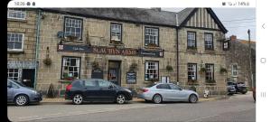 two cars parked in front of a brick building at St aubyn arms Hotel in Praze an Beeble