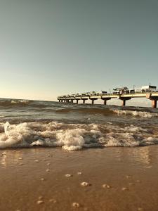 a beach with a pier in the water at Gryfhaus - Pokój Bosmański, kameralny, 22 m2, parking, Wi-Fi, blisko morza, wysoka ocena 9,9 in Międzyzdroje +41 photos