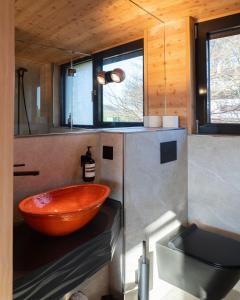 a bathroom with a large wooden bowl on a counter at Oak - K1 Baumhaus in Odenthal