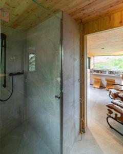 a bathroom with a shower with a glass door at Oak - K1 Baumhaus in Odenthal