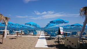 a row of blue umbrellas and chairs on a beach at Frank Apartments in Amoudara Herakliou