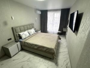 a bedroom with a bed with a marble floor at 1 room Ridnyi Dim Apartment in Cherkasy