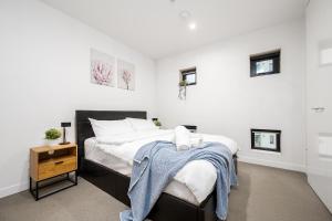una camera con un grande letto e un comodino di Southbank 2BR Apartment Steps from Crown Casino a Melbourne