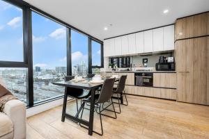 una cucina e un soggiorno con tavolo e sedie di Southbank 2BR Apartment Steps from Crown Casino a Melbourne