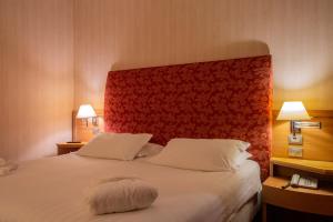 a bedroom with a large bed with a red headboard at Poli Hotel in San Vittore Olona +58 photos