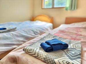 a bed with two blue folded towels on it at 名西旅館花 in Tokushima