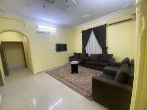 a living room with a couch and a tv at العييري للشقق المخدومة المدينة 3 in Al Madinah