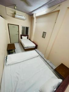 una habitación vacía con 2 camas en una habitación en Shree Shivay Residency, en Ujjain 4 fotos más